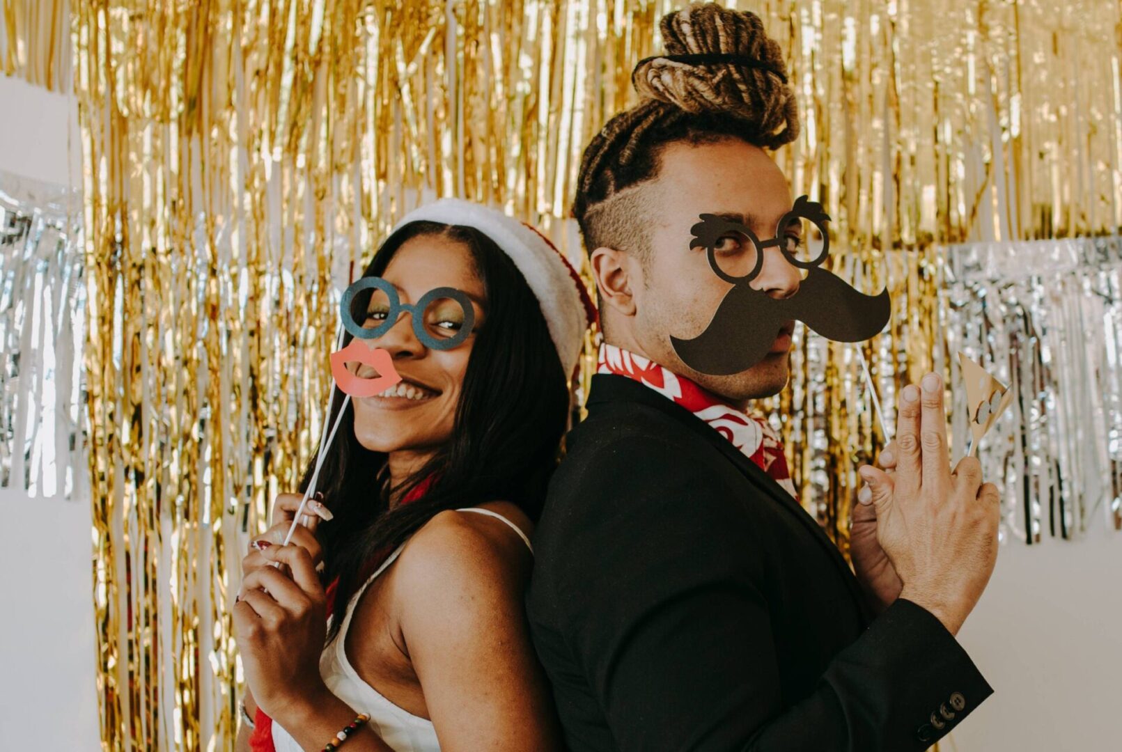 A man and woman wearing fake mustaches and glasses.